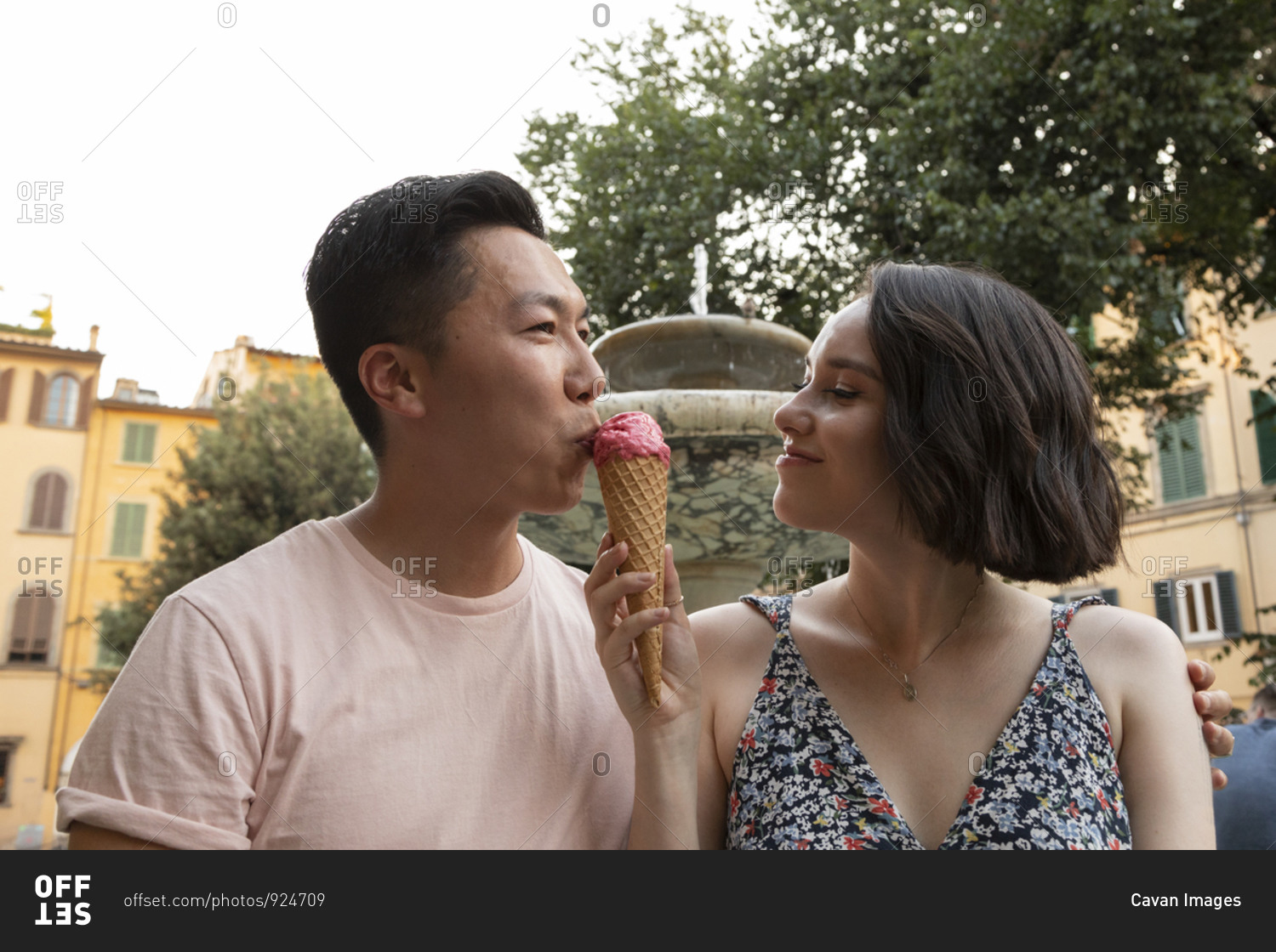Attractive mixed race couple enjoying gelato in front of fountain