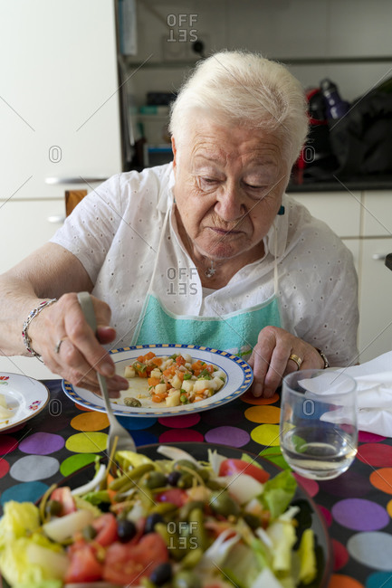 Old lady eating alone healthy food at home