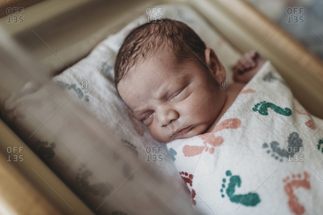 Close up detail of newborn boy face in hospital bassinet