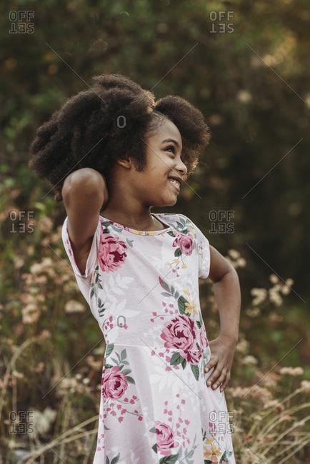 Portrait of young school-aged confident girl posing in field