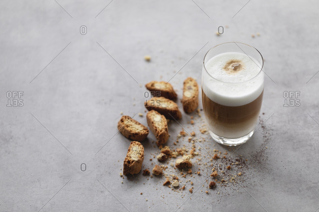 Latte macchiato in glass with cantuccini biscuits.