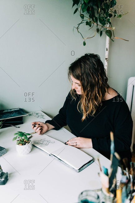 Stock photo of a lettering artist at work with her sketch book.