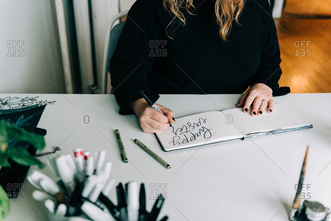 Stock photo of a lettering artist at work with her sketch book.