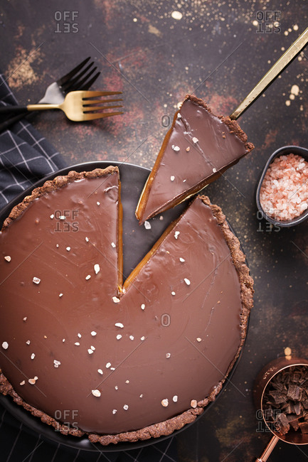 Cuted slice of a salted caramel and chocolate tart top view