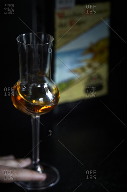 Hand swirling a glass of amaro