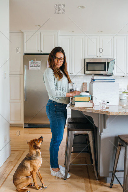 Woman interacting with her dog while working from home