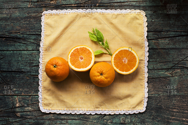 Halves of fresh oranges on a wooden dark rustic table on a dark background