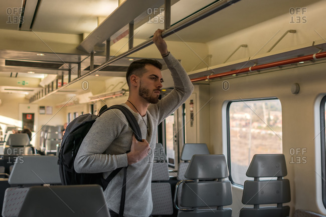 Focused young male passenger riding metro in daytime
