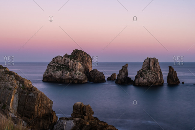 Picturesque scenery of rocks in peaceful sea and skyline in twilight in Costa Brava