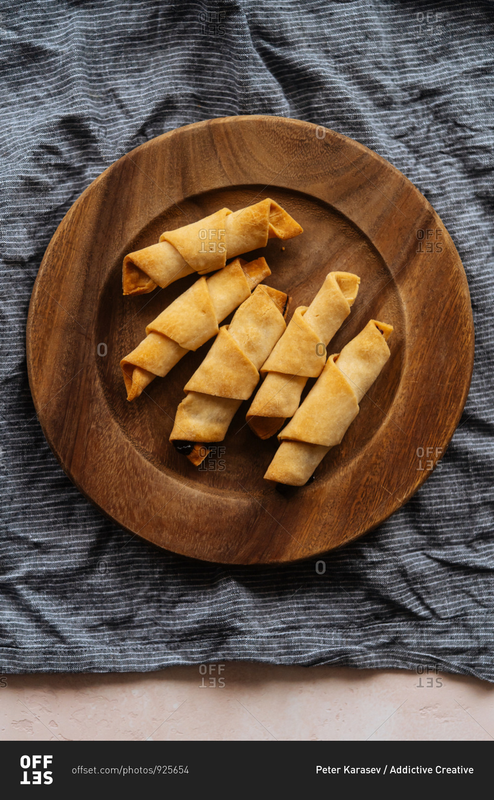 From above tasty crunchy appetizing croissants in wooden plate on linen on table