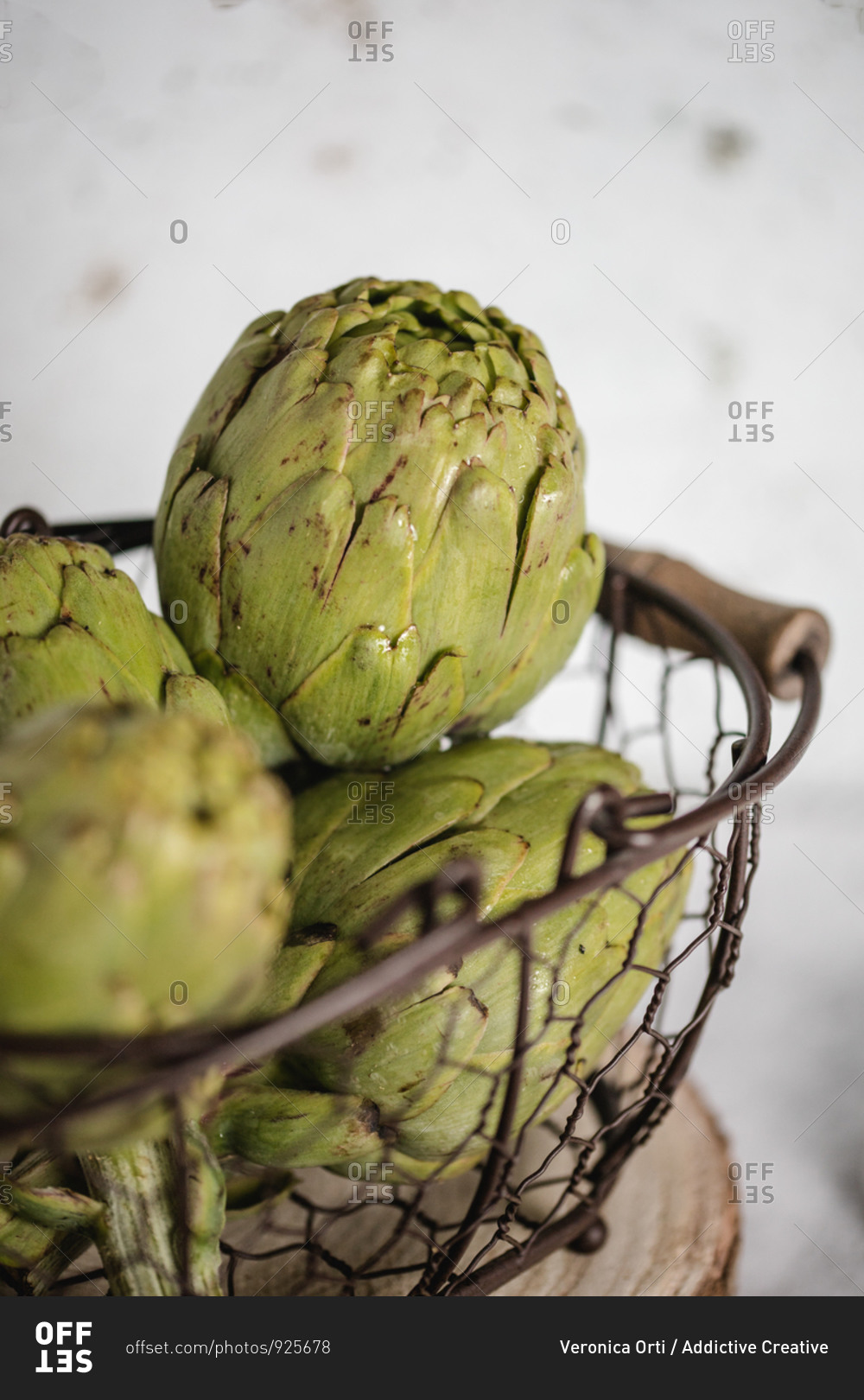 Bright green artichokes in metal stylish basket decorated with green