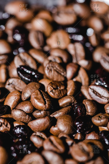 Closeup textured background with mixed black and brown fresh aromatic roasted coffee beans