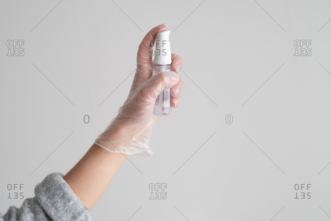 Hands spraying disinfectant spray into the air