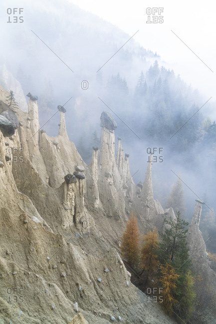 Colorful trees on rocks of the Earth Pyramids in autumn, Perca (Percha), province of Bolzano, South Tyrol, Italy, Europe