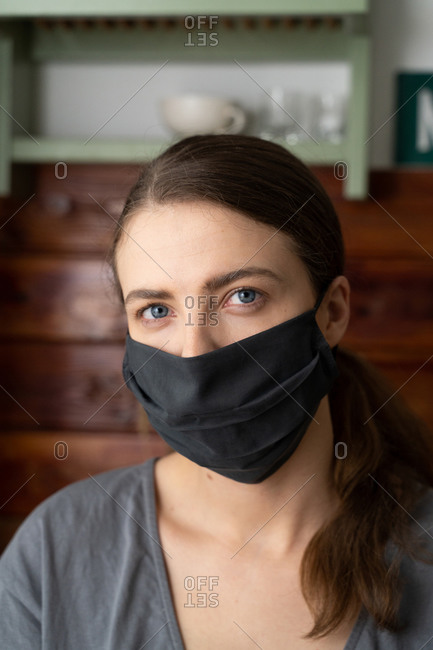 Woman puts a silk mask on her face to protect herself from the covid-19 virus