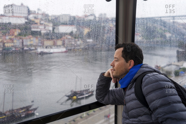 Pensive man inside th Porto cableway looking away the panoramic view