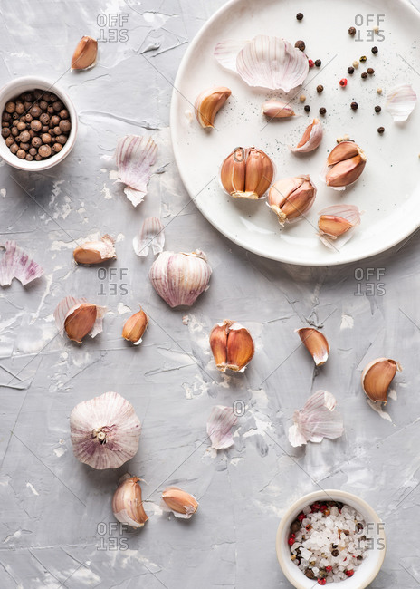 Overhead view of garlic bulbs and garlic cloves over gray background