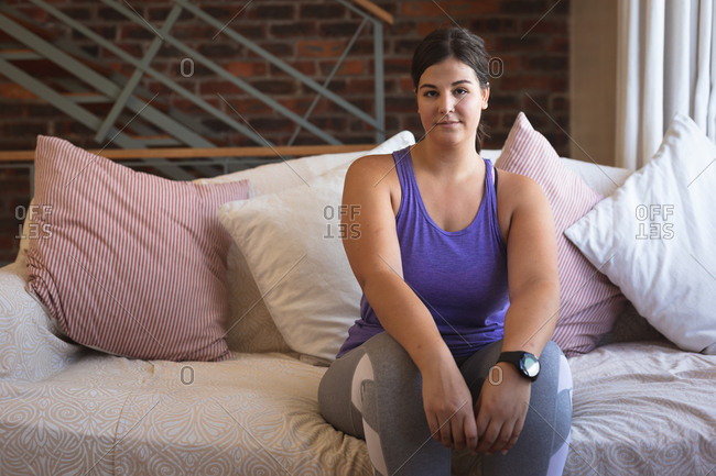 Caucasian female vlogger at home in her sitting room, preparing to demonstrate exercises for her online blog. Social distancing and self isolation in quarantine lockdown.