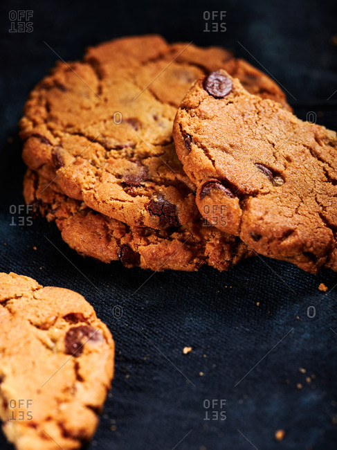 Delicious chocolate chip cookies on dark blue textile background