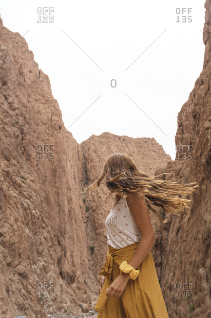 Young woman looking at rocks turning her head- Ouarzazate- Morocco