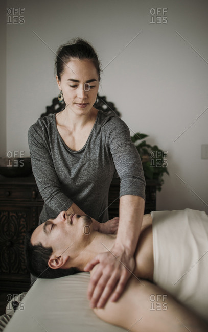 Female massage therapist treats male Hispanic patient