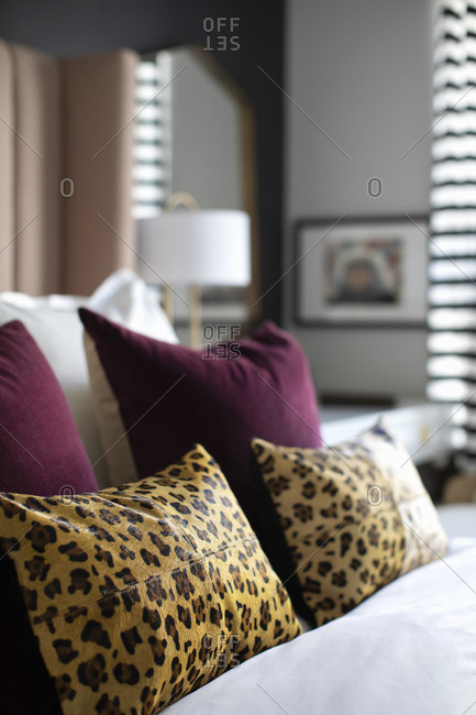 Animal print and mauve pillows on a bed