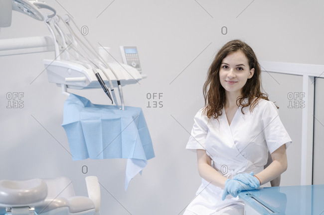 Female dentist sitting in clinic- smiling