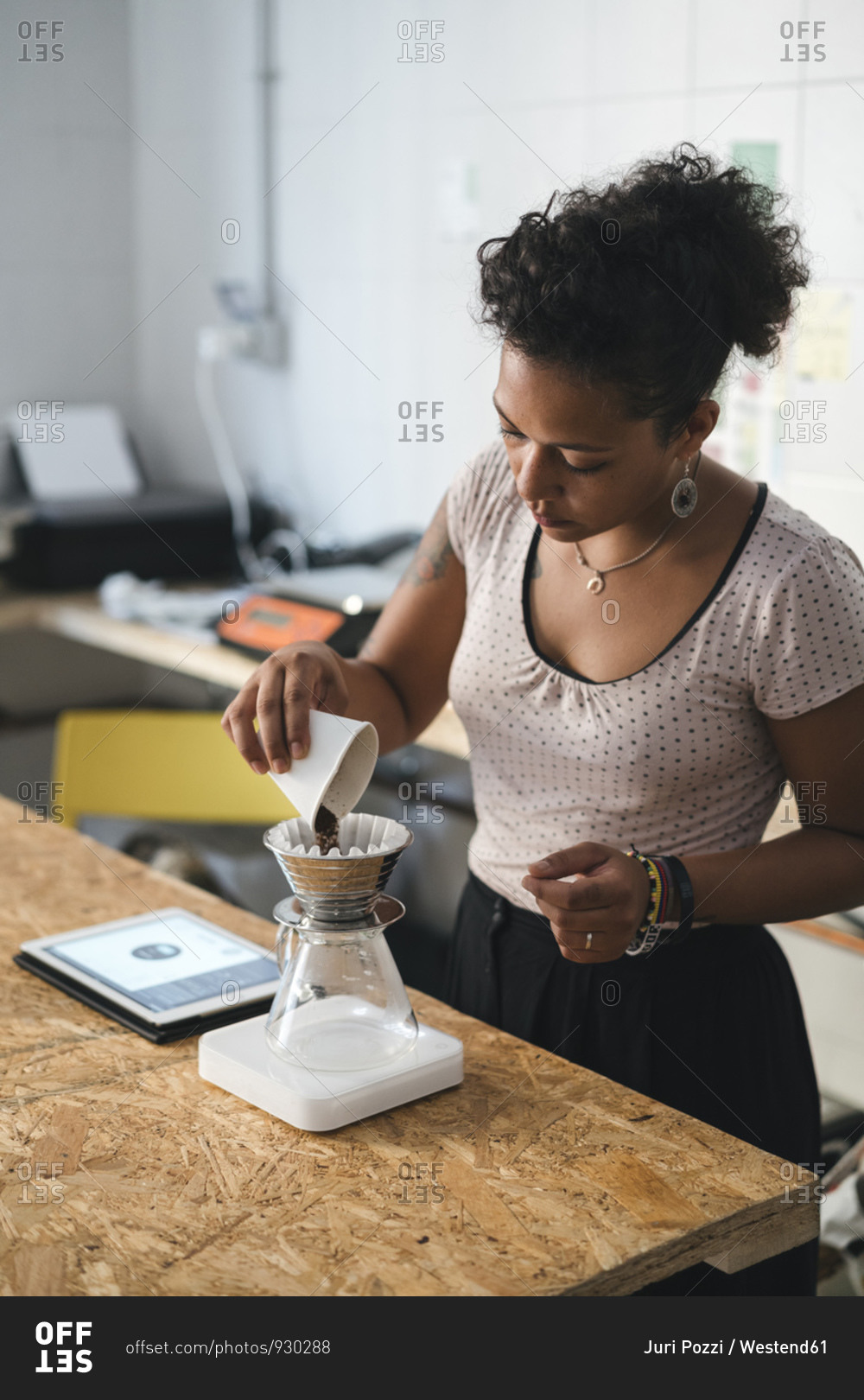 Woman working in a coffee roastery preparing fresh filtered coffee
