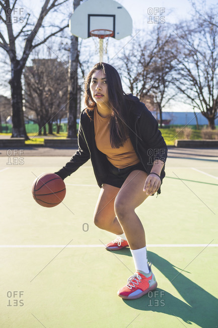 Portrait of female basketball player in action on court