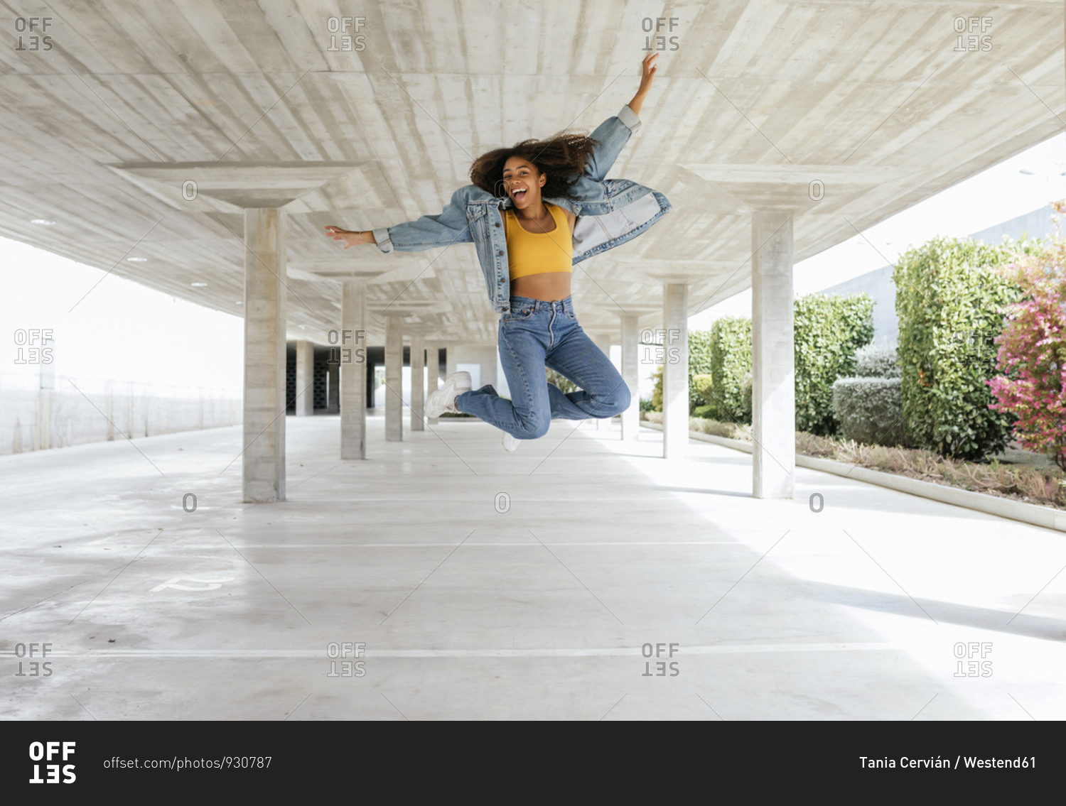 Smiling woman jumping in empty parking deck
