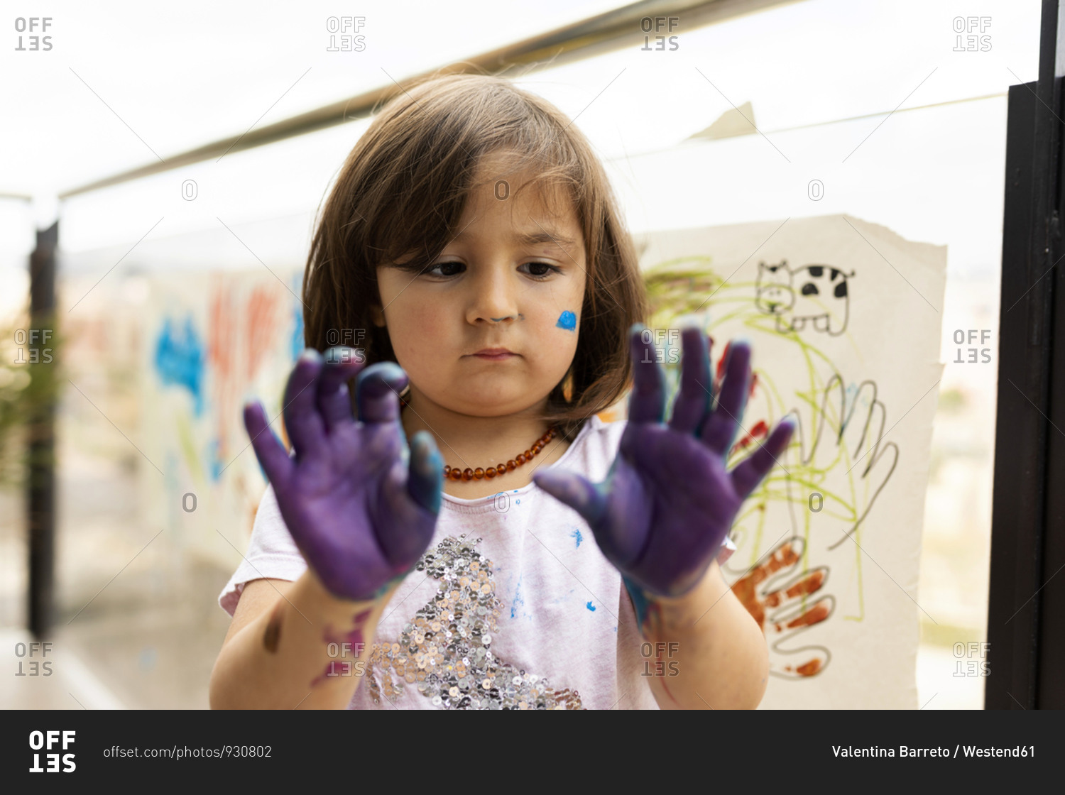Little girl messing around with her painted hands