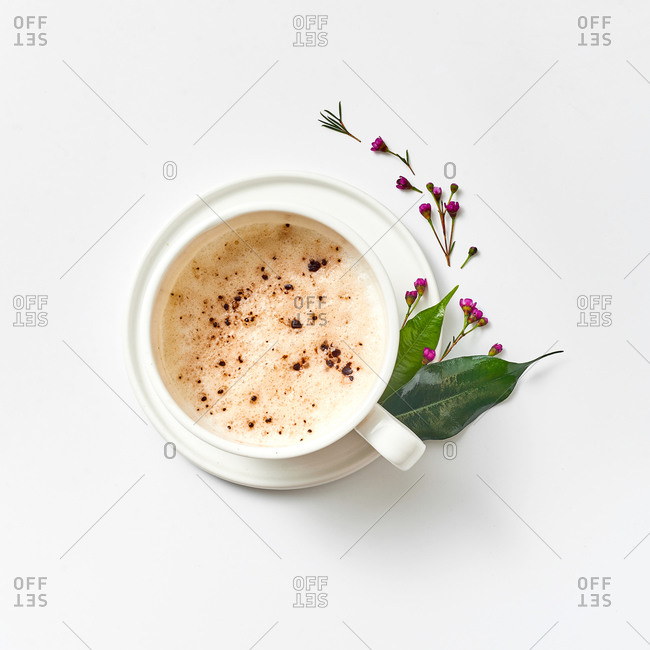 Latte sprinkled with chocolate, decorated with spring plants and flowers