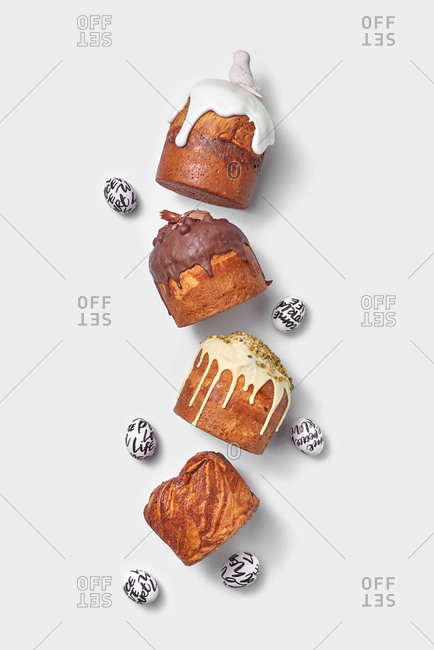 Homemade freshly baked Easter breads and decorative eggs on a light grey background