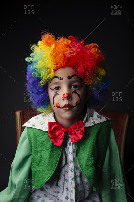 Young boy dressed as a clown with rainbow wig