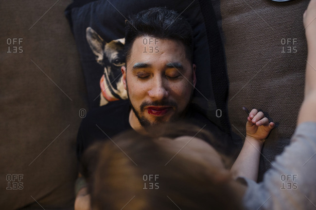 Overhead view of kid putting makeup on father