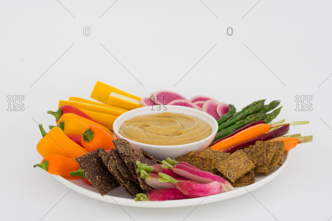 Vegan hummus with a variety of crisp vegetables and crackers