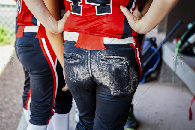 Rear view of female softball player in dugout