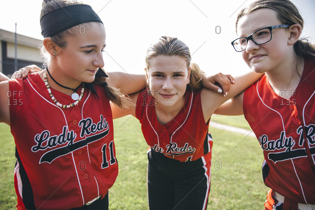 Girl softball team huddle on baseball field