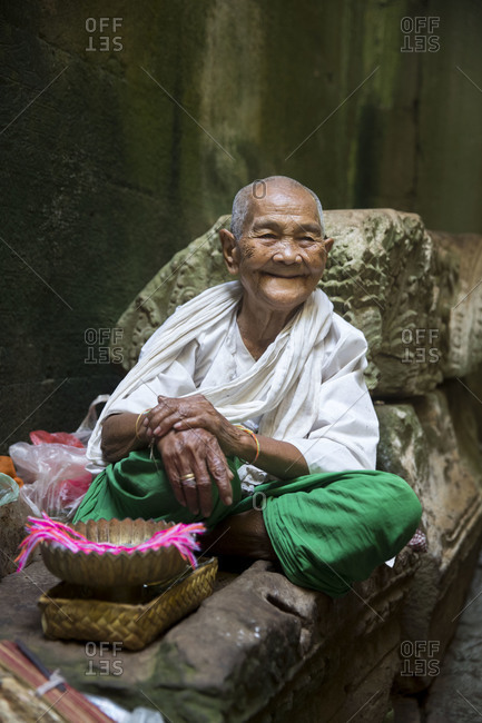 Siem Reap, Angkor, Temple Preah Khan, old lady prays for you and then ties a ribbon around your hand