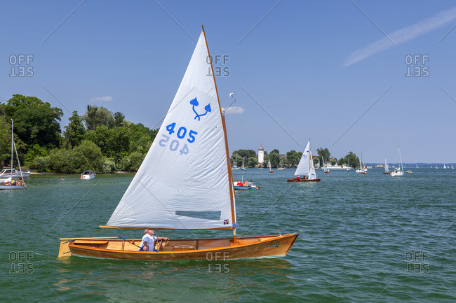 July 11, 2015: Sailor Chiemseeplatte on Lake Chiemsee behind it Fraueninsel, Frauenchiemsee, Chiemgau, Upper Bavaria, Bavaria, Southern Germany, Germany, Europe