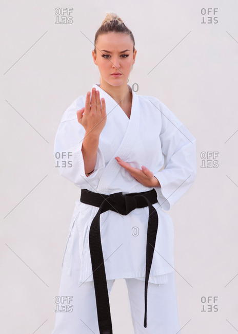 Young female karate expert practicing fighting positions with he