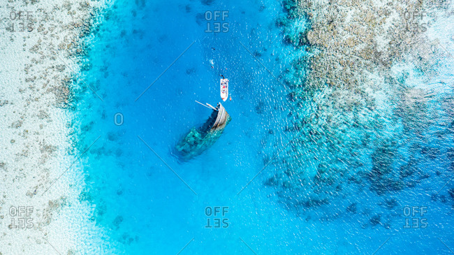 Aerial view of a ship wreck and a boat near Keyodhoo, Vaavu Atoll, Maldives, Indian Ocean with people snorkeling