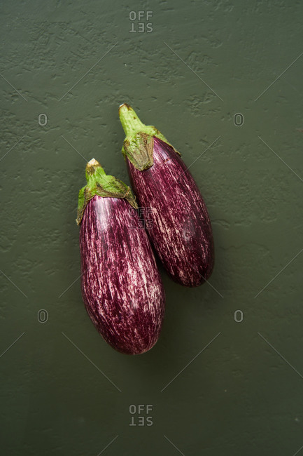 Eggplants on green textured background