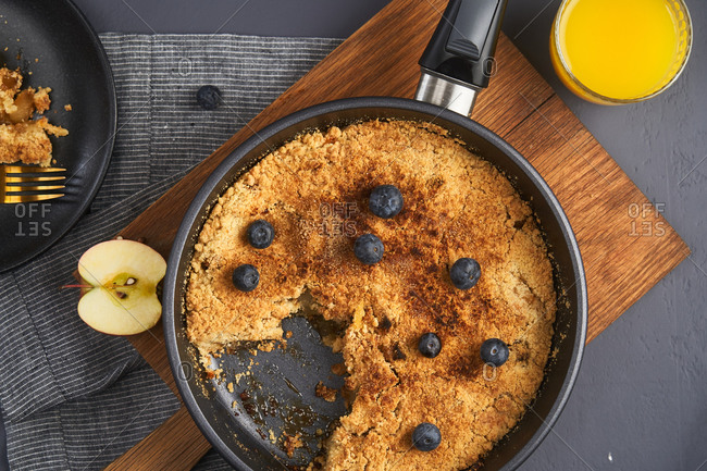 Apple crumble in a skillet topped with blueberries
