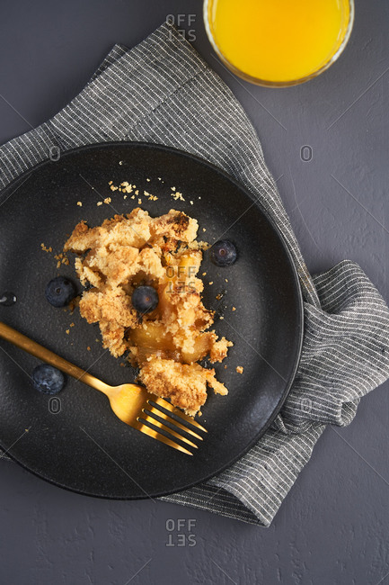 A slice of apple crumble topped with blueberries