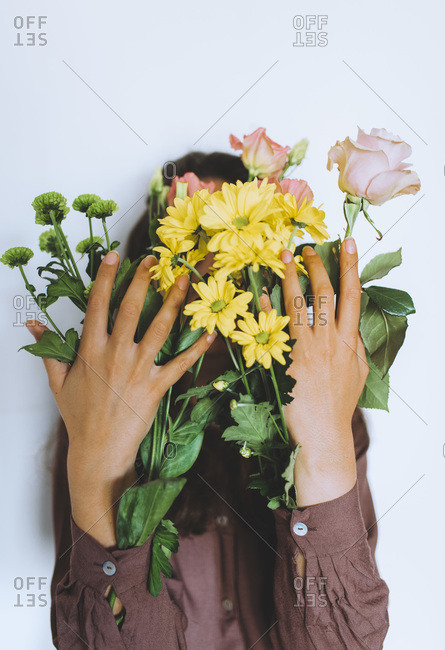 Woman holding a variety of spring flowers in her sleeves