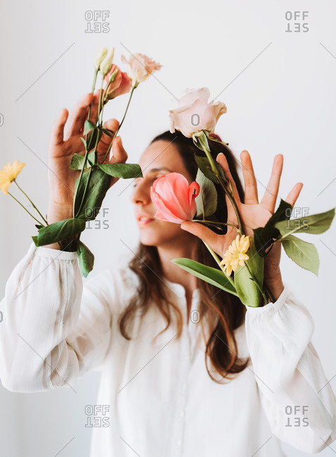 Woman holding a variety of flowers in her sleeves