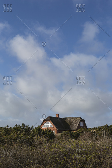 Denmark- Romo- Clouds over rustic house with thatched roof