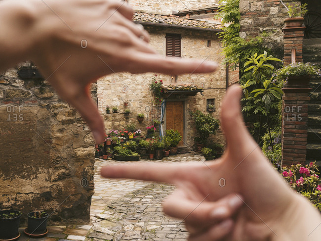 Woman finger framing a house in picturesque old town- Greve in Chianti- Tuscany- Italy
