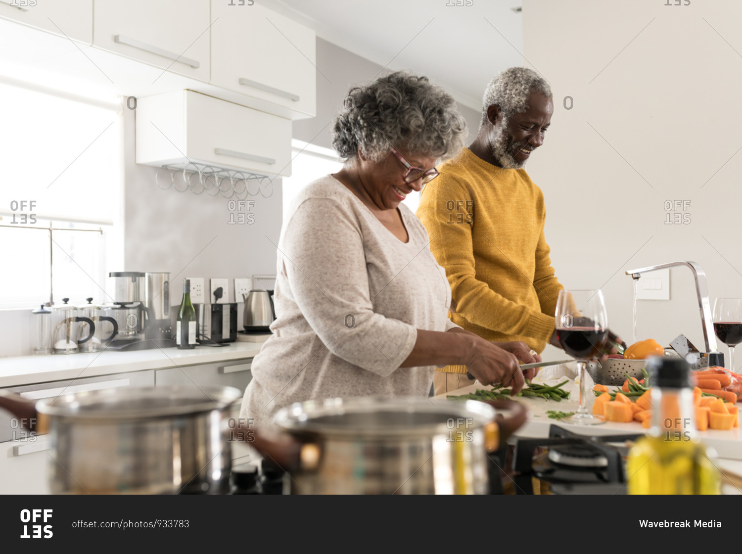 A senior African American couple spending time at home together, social distancing and self isolation in quarantine lockdown during coronavirus covid 19 epidemic, preparing food, smiling